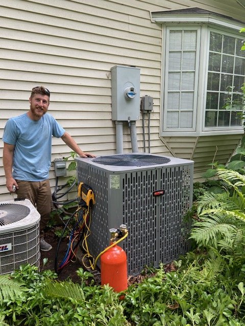 MAC Services technician inspecting a home air conditioning unit